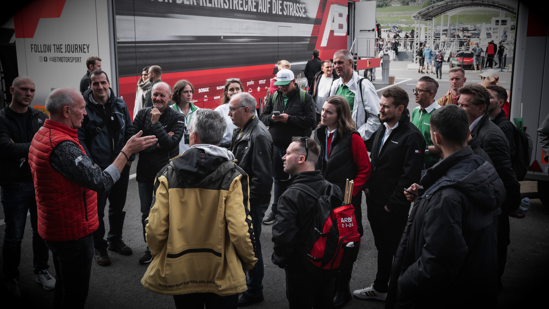 Harry Unflath mit einer Gruppe Fans & Partner vor einem ABT Motorsport LKW